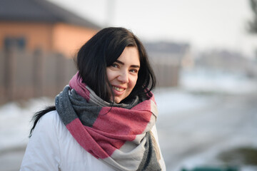 Portrait of a smiling brunette woman at sunset in winter.