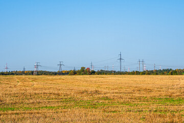 Fototapeta na wymiar Panoramic view of the cell towers standing in a row on the horizon in the autumn field.