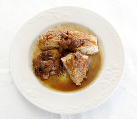 guinea fowl with mushrooms is a typical food of the Marche region and central Italy isolated on white background