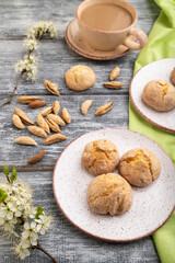 Almond cookies and a cup of coffee on a gray wooden background. Side view.