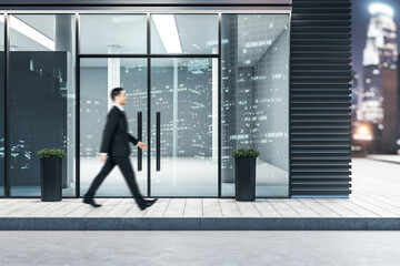 Fototapeta na wymiar Businessman walking near glass entrance in modern business center
