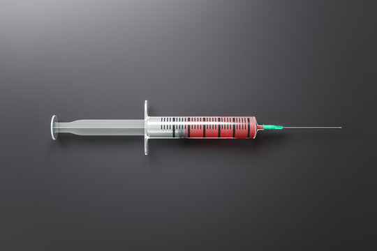Syringe with red injection on gray background.