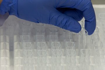 Scientist taking cuvette quartz to place the sample in the spectrophotometry