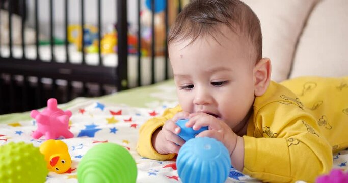 infant, childhood concept - close-up of smiling happy Baby plays with a teether. Teeth cutting. First teeth. Joy toothless 7 months baby bite, gnaws teether toy
