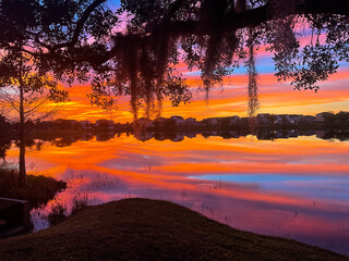 Naklejka na ściany i meble Beautiful pink, orange and blue sunset reflecting on a lake