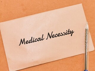 Text MEDICAL NECESSITY written on brown envelope.Medical concept.