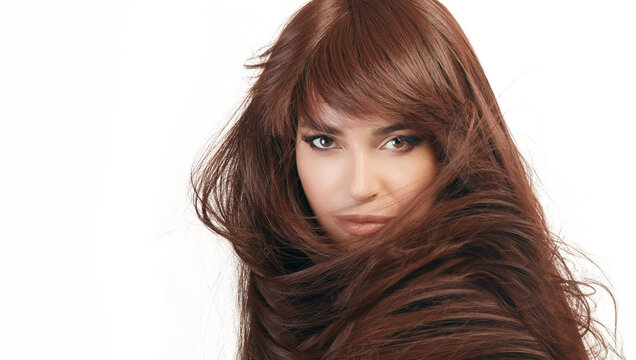 Beautiful woman shaking a healthy shiny long hair with a perfect chocolate brown hair color