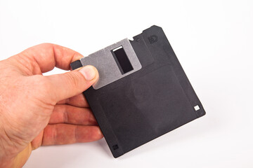 Old computer and data storage technology, hand heldblack magnetic floppy disk 3½ inches, isolated...