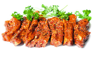 Uncooked raw marinated style pork belly chops on a white background with coriander leafs. Korean style marinade over the slices. Meat industry product