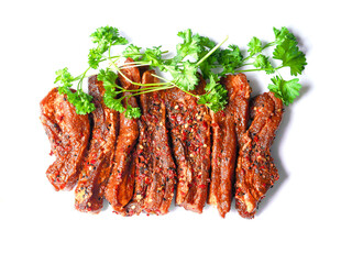 Uncooked raw marinated style pork belly chops on a white background with coriander leafs. Korean style marinade over the slices. Meat industry product