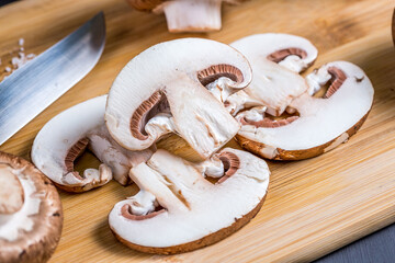 Close-up of a slice of edible mushroom champignons on a cutting board