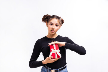 girl with curly hair in a black jacket and jeans holding a gift in a red box on a white background