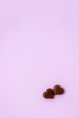 Сhocolate hearts lie together on pastel background. Love or Valentine's Day concept. Copy space, vertical orientation