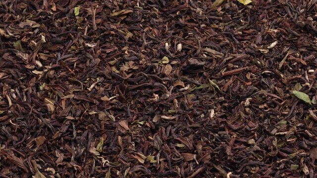 rotating dried luxury black tea leaves background closeup