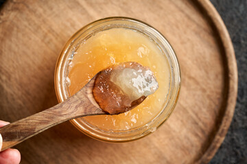 Cooled congealed beef bone broth on a wooden spoon