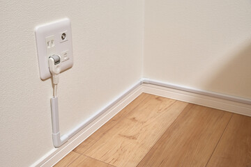 コンセントから伸びた延長コードと配線モール