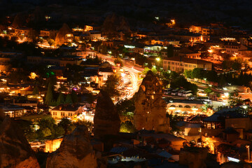 The chimney rock formations in Goreme, Cappadocia, Turkey , at dusk. The evening lights among volcanic rocks make the scene surreal