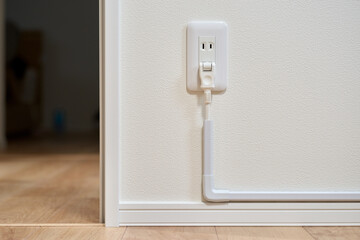 コンセントから伸びた延長コードと配線モール