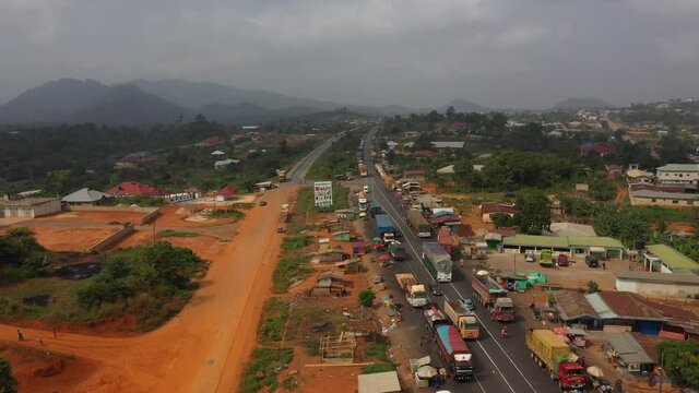 Aerial trucks parking rural village highway Ghana Africa part 2 4K. Old busy congested market area and truck parking in rural village between Accra and Kumasi Ghana, Africa. Place to buy and sell.