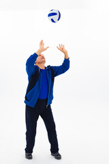 Old male athlete plays with ball on white background