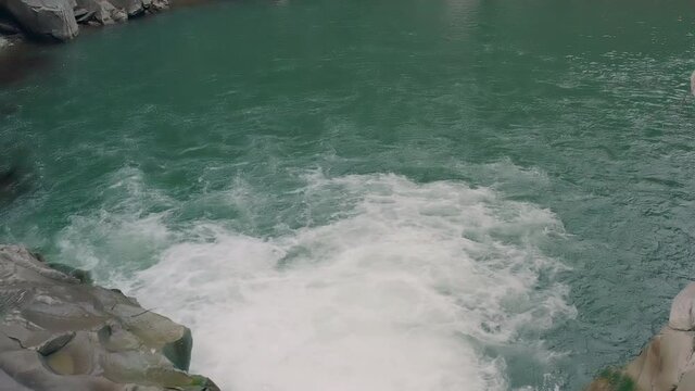 Waterfall in the Winter. Rapid Flow of Water from a Mountain Creek and Stone Rapids with Snow. The river Prut in Ukrainian Carpathians in Yaremche city.Melting ice and snow on the river in the forest.