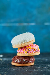 Pile of colorful puffy cookies on blue background