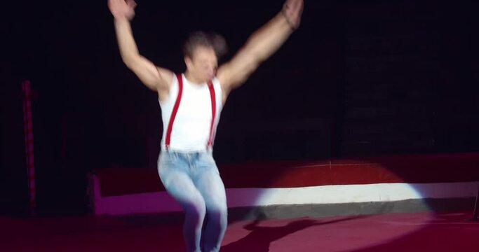 Athletic equilibrist jumping from the string doing flips, circus, 4k