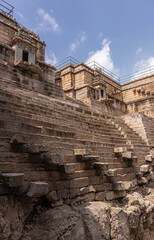 Lakkundi, Karnataka, India - November 6, 2013: Musakeena Bhavi step tank. Brown stone Flank of dry stair well seem from halfway down. Blue cloudscape adds color.