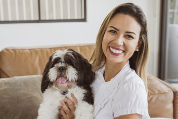 Portrait of beautiful Brazilian woman and her pet shih tzu dog at home, best friend, family love