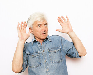 portrait senior mature man, looking shocked, scared trying to protect himself in anticipation of unpleasant situation, isolated white background. Negative emotion facial expression feeling