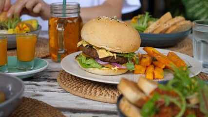 Dolly shot on various healthy vegan meals at the table- salads, burgers, snacks and drinks. Clean eating concept