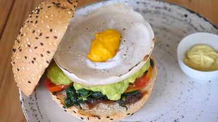 Top view of vegan burger with plant based egg alternative served on top. Healthy vegan lifestyle