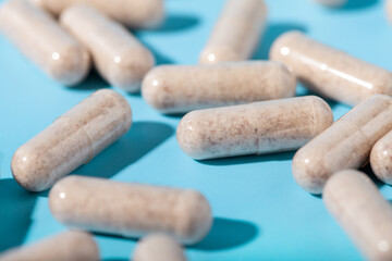 Vegetarian multivitamin capsules on a blue background. Food supplement, multivitamins, medicines,...