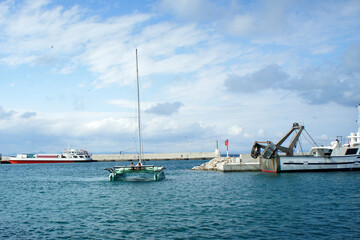 Green catamaran in the port of La Savina on the island of Formentera, Spain.