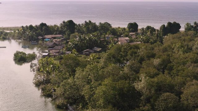 Village of Jovi on the Colombian Pacific shore, drone arial view with ethnic settlement huts, rainforest and Pacific Ocean