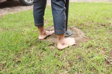 Two small children's feet stepped on the grass in the garden.