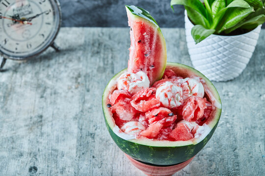 Ice-cream inside watermelon and clock, pot with plant