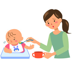 離乳食を嫌がる女の赤ちゃんと母親