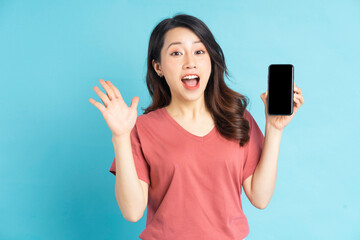 Beautiful Asian woman holding smartphone in hand with a cheerful expression