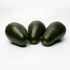 green avocado on a white background with reflected shadows