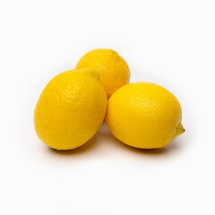yellow lemons on a white background with reflected shadows