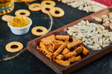 Plate of assorted snacks and crackers on dark table