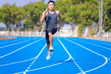 Obraz premium young asian man athlete running and training on the track
