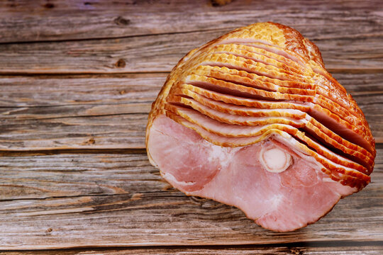 Spiral sliced pork ham isolated on wooden background.