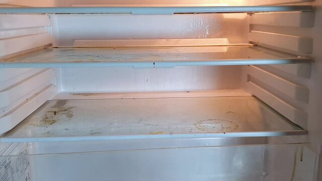 slow pedestal down, overview over a dirty empty fridge, wide angle