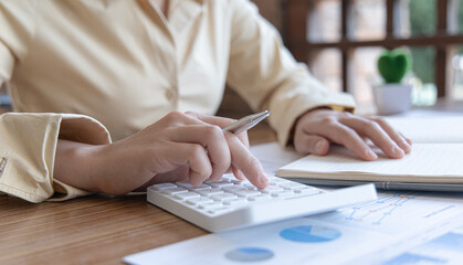 Head of accounting is recording the company's financial growth statistics using graphs as a reference for reviewing and analyzing the results, Taking notes and analyzing data graphs in office.