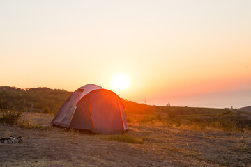 Installed tourist tent in the mountains with a view of the sea and sunrise. Domestic tourism, active summer trip, family adventures. Ecotourism, camping, sports mountain hiking. Ayu-Dag, Crimea.