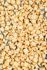 Scattered alphabet crackers on blue table