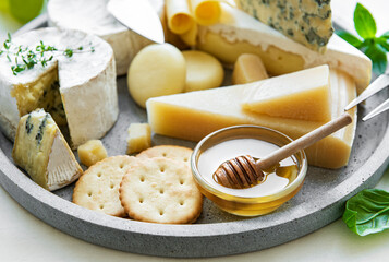 Various types of cheese, grapes and honey