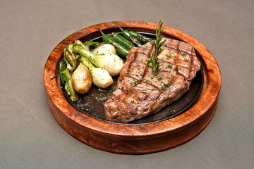 Grilled beef steak with serrano peppers and roasted onions Delicious beef steak on gray background, ribeye